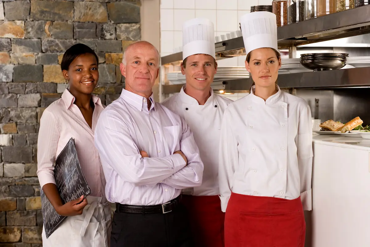 Equipo de cocina trabajando en un restaurante: chefs y ayudantes en servicio